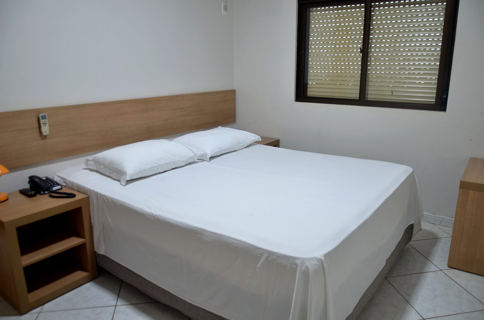 Quarto casal conforto com cabeceira de madeira